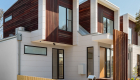 exterior photography of West Footscray townhouse new development, architectural design, iron bark wood features, white facade, roger thompson photography, blue sky,