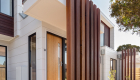 exterior photography of West Footscray townhouse new development, architectural design, iron bark wood features, white facade, roger thompson photography, blue sky,